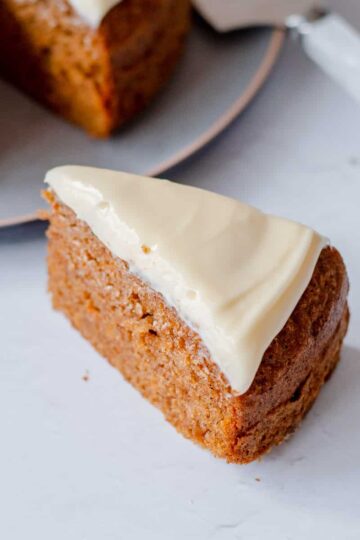 A slice of carrot cake with cream cheese icing on top.