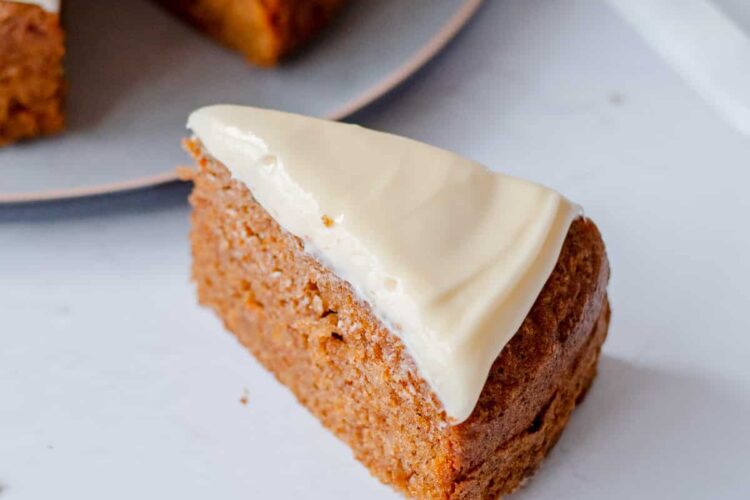 A slice of carrot cake with cream cheese icing on top.