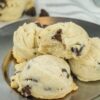 A plate of chocolate chip cookies is displayed. The cookies have a soft texture with visible chocolate chips embedded in them.