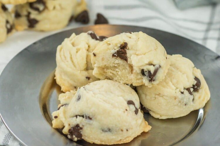 A plate of chocolate chip cookies is displayed. The cookies have a soft texture with visible chocolate chips embedded in them.