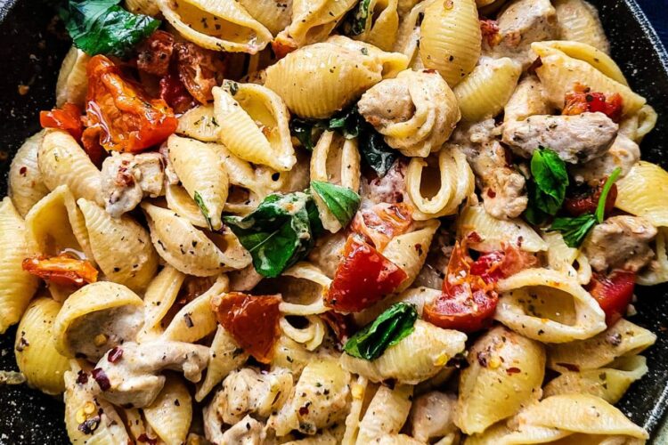Sun dried tomato pasta with chicken in a frying pan.