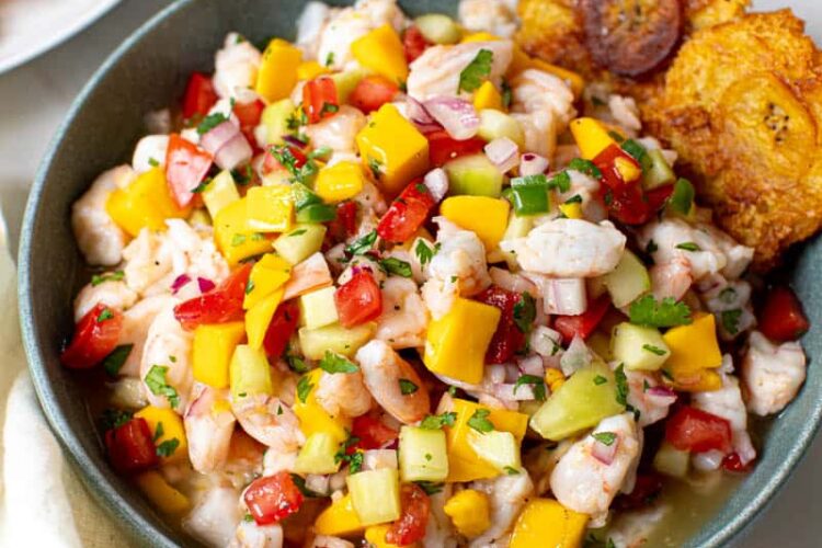Mango ceviche in a bowl with two plantains on the side of the bowl.
