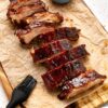 Cut oven baked ribs on a piece of parchment paper after baking in the oven.