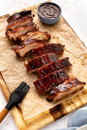 Cut oven baked ribs on a piece of parchment paper after baking in the oven.